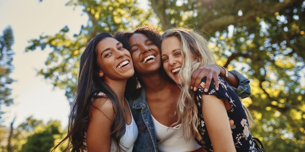 three friends laughing while aware of empowering women in recovery