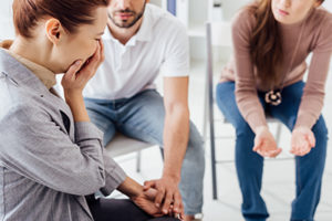 a woman cries during group therapy at drug and alcohol rehab programs