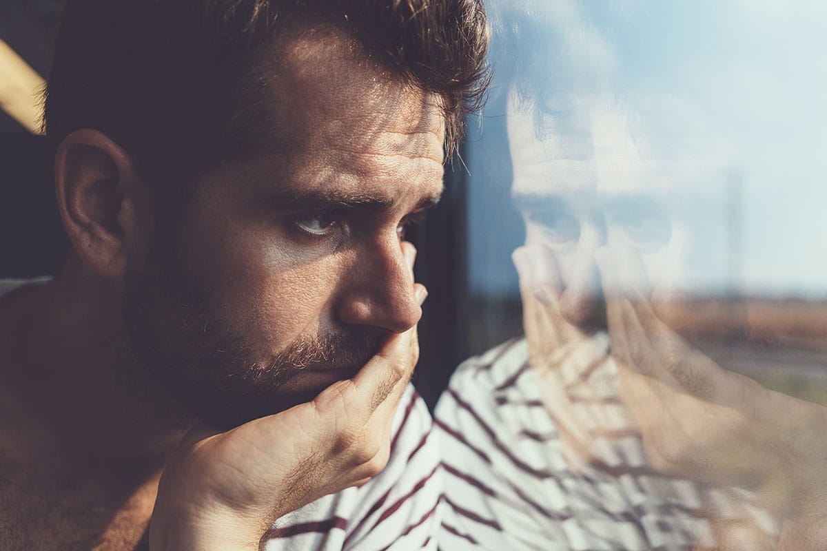 a man stares uncomfortably out the window thinking about how he needs cocaine addiction treatment to overcome his dependence on cocaine