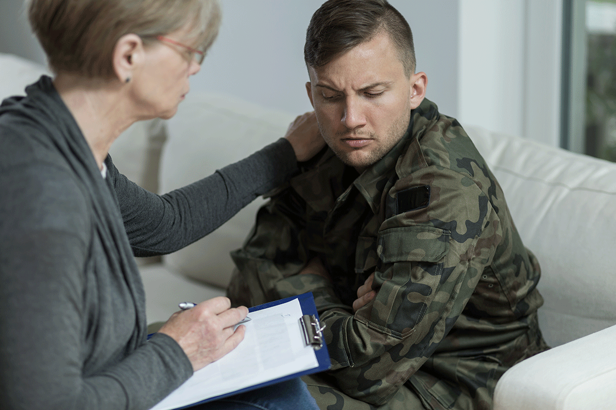 a therapist comforts a member of the military after talking about veterans and addiction statistics