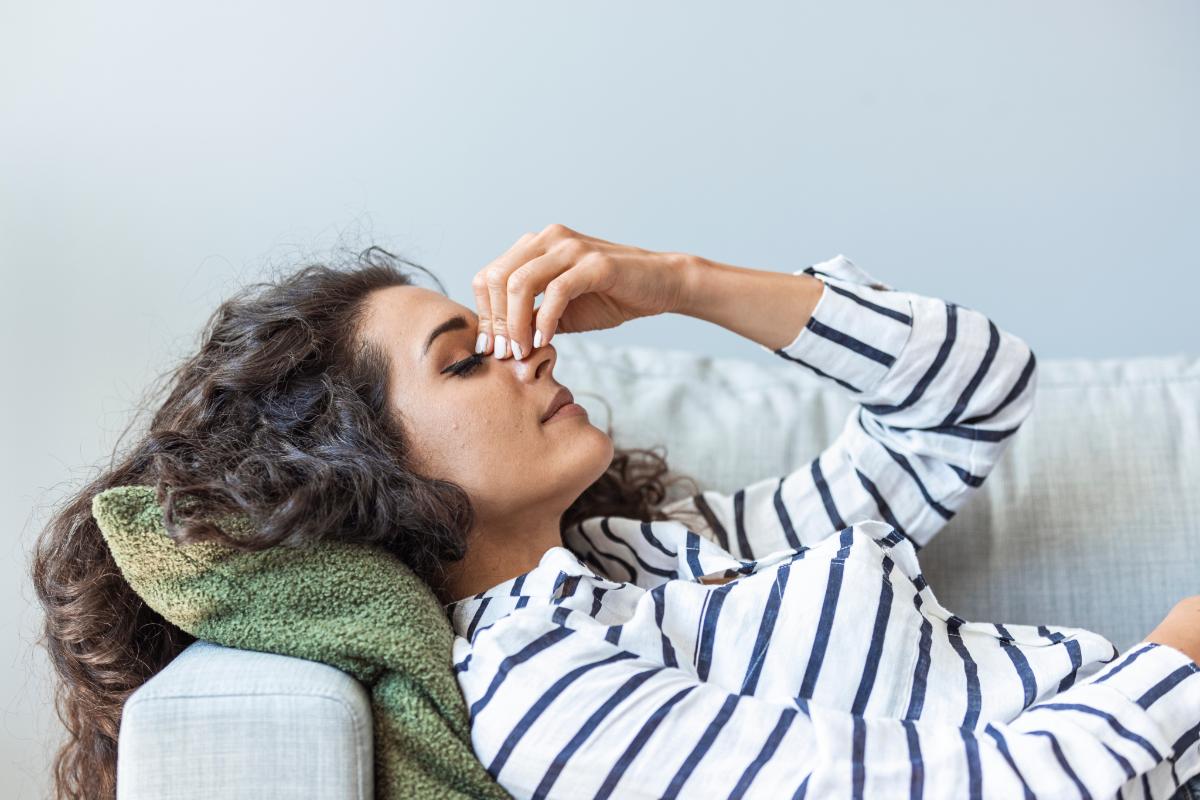 woman resting on couch with hand on face thinking about heroin and the brain