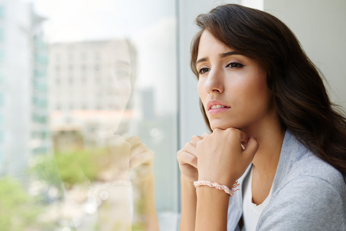 Person looking out window contemplating trauma and mental health